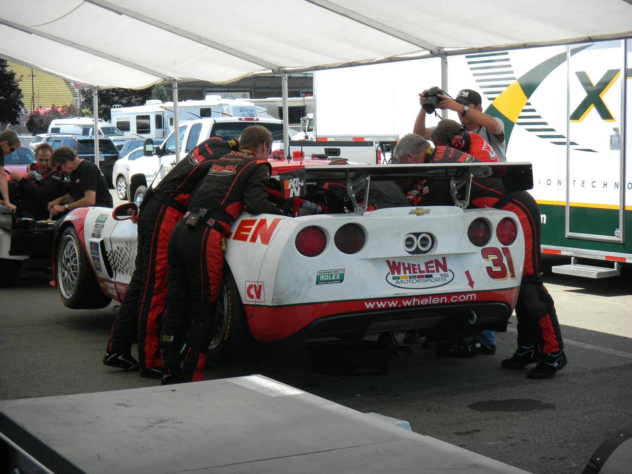 Boris Said, in the background, having lunch while the crew thrashes on his car.