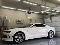 Camaro in garage with lights.